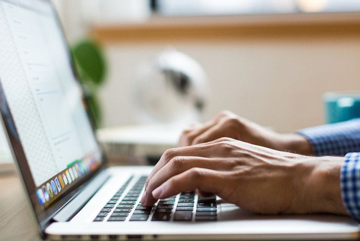 man with hands on the keyboard of a laptop