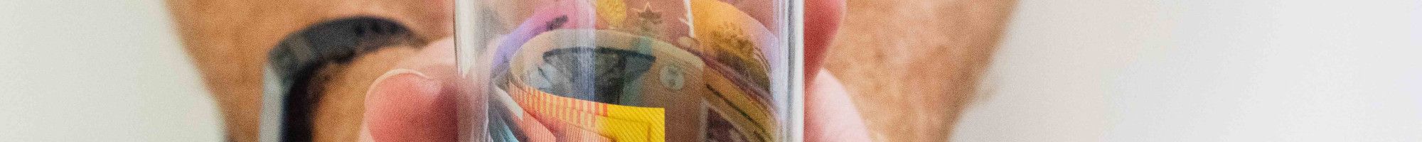 man holding a jar of cash