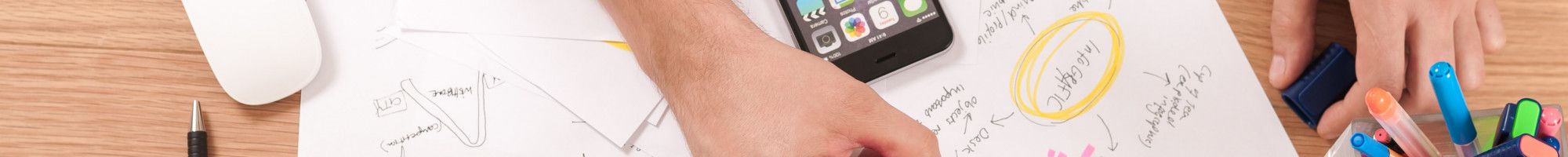 person working at computer with papers on the desk